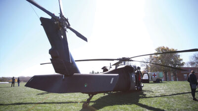 An Army Helicopter parked on the practice field behind Walz Complex