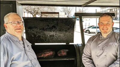 Patrick O'Brien (right) smokes meat for Taco Tuesday at Concordia