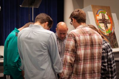 Concordia's campus pastor leads students a small group of students in prayer