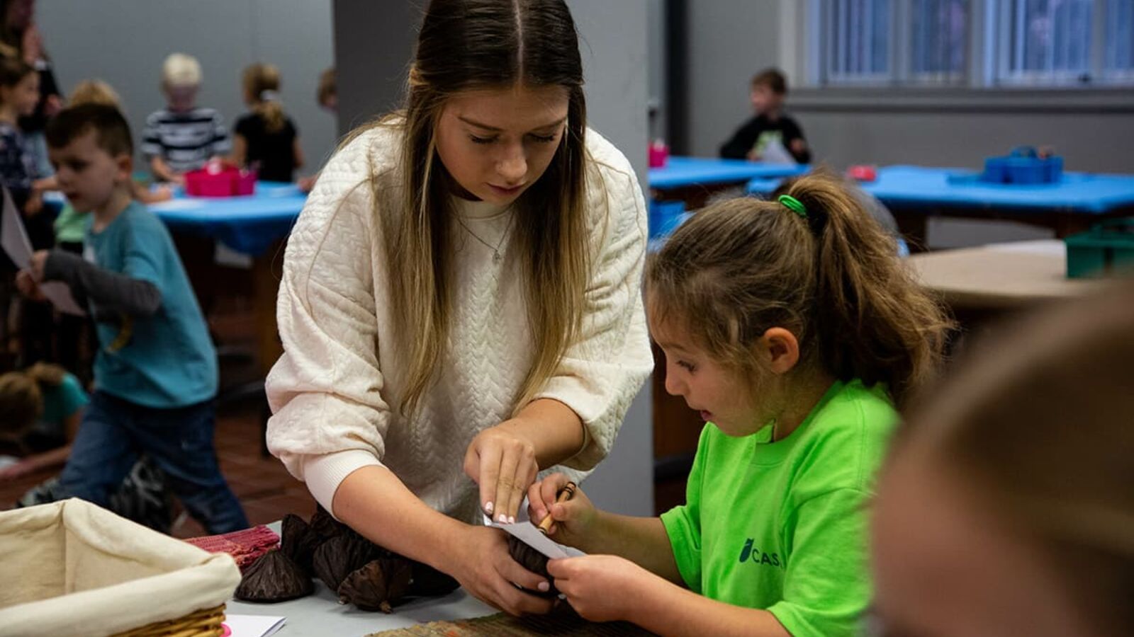 A Concordia student assisting a child with an art project