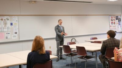 Speech Team member presenting while her other team members listen