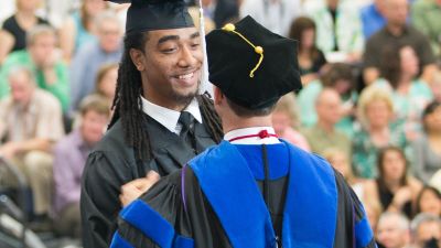Student receives his diploma during commencement.