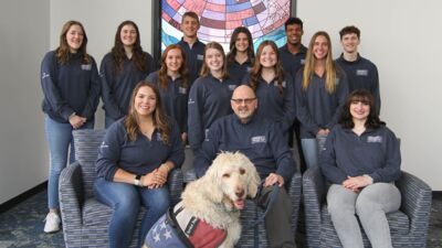 Members of the 2023 Collegiate Leadership Competition Team posed in front of the Borland Collaboration center stained glass window. 