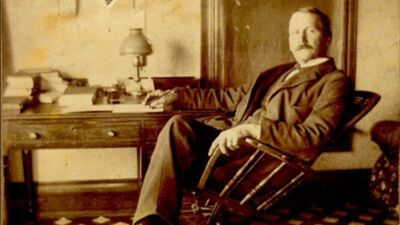 Rev. George Weller sitting at his desk. 