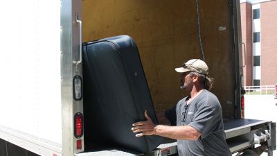 A man loads one of the mattresses Concordia donated to People's City Mission on July 13.