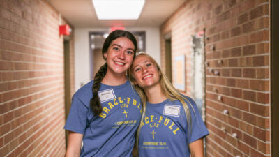 Two students smiling in a dorm building