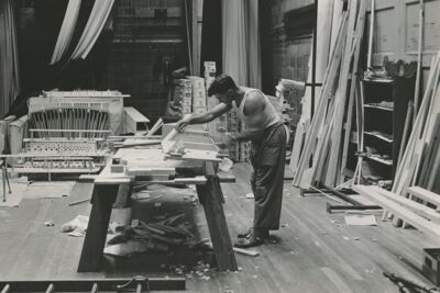 Worker constructing the chapel organ on the stage in Weller