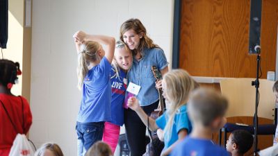 A middle school music teacher hugging a student