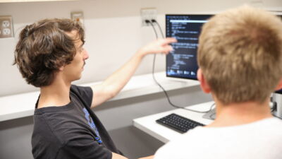 Two students analyzing code they've written during a programming competition.