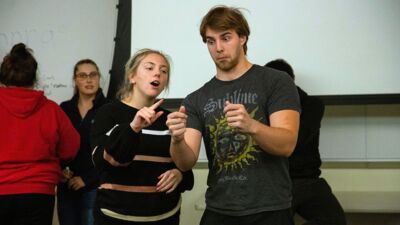 Two improv students acting out a scene during a practice session.