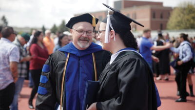 Professor chatting with a student after graduation