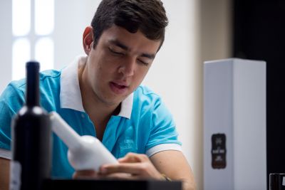 A student examining a corked bottle