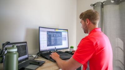 A man working from a home office on a computer