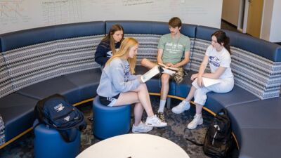 Four student gathered in a lounge area of the Dunklau Center, reading the Bible