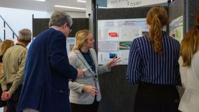 A student discussing her research with a professor at the Academic Research Symposium