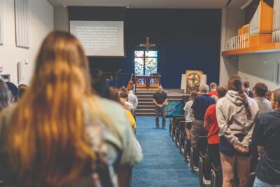 Campus pastor leading everyone in prayer at chapel