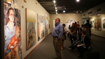 A man appreciating an art piece in a art expo