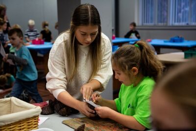 A Concordia student assisting a child with an art project