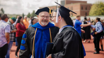 Professor chatting with a student after graduation