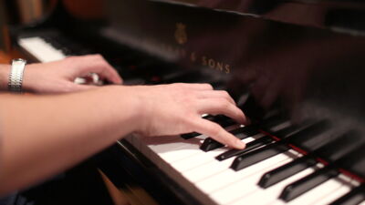 Close up of hands on the keys of a Steinway piano.