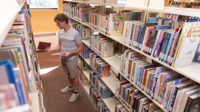 A student looking at books in the library