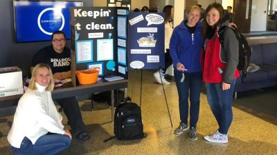 Students and faculty in front of the health center table