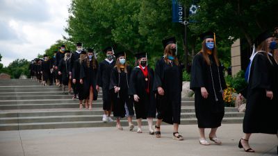 Concordia University, Nebraska Class of 2020 graduates walk through the plaza during the graduation processional.