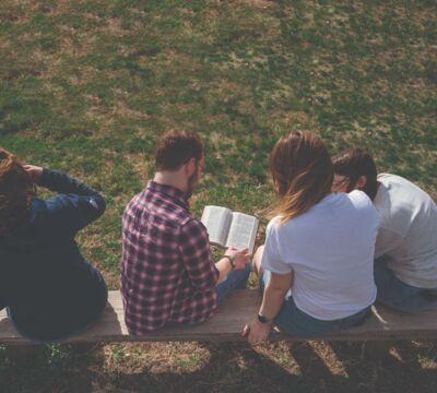 Students reading the Bible out on the lawn