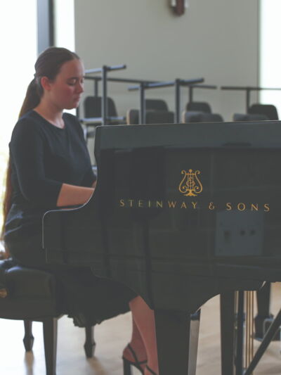 Music student playing on a Steinway piano.